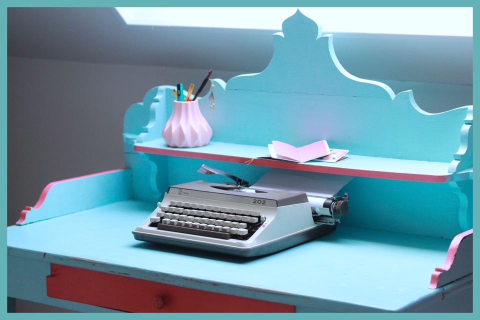 Photo d'ambiance avec une machine à écrire sur un bureau vintage rose et bleu